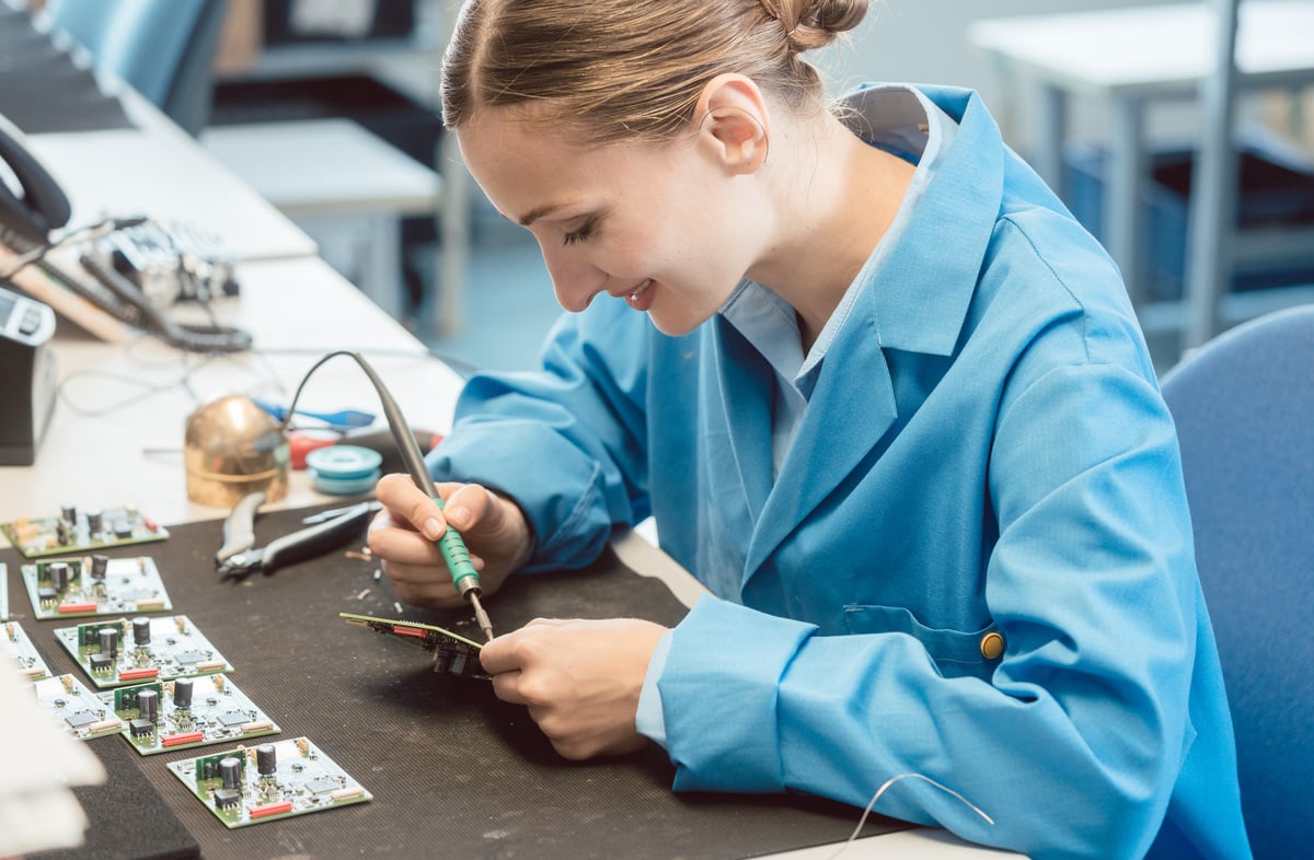 Worker in Electronics Manufacturing Soldering a Component